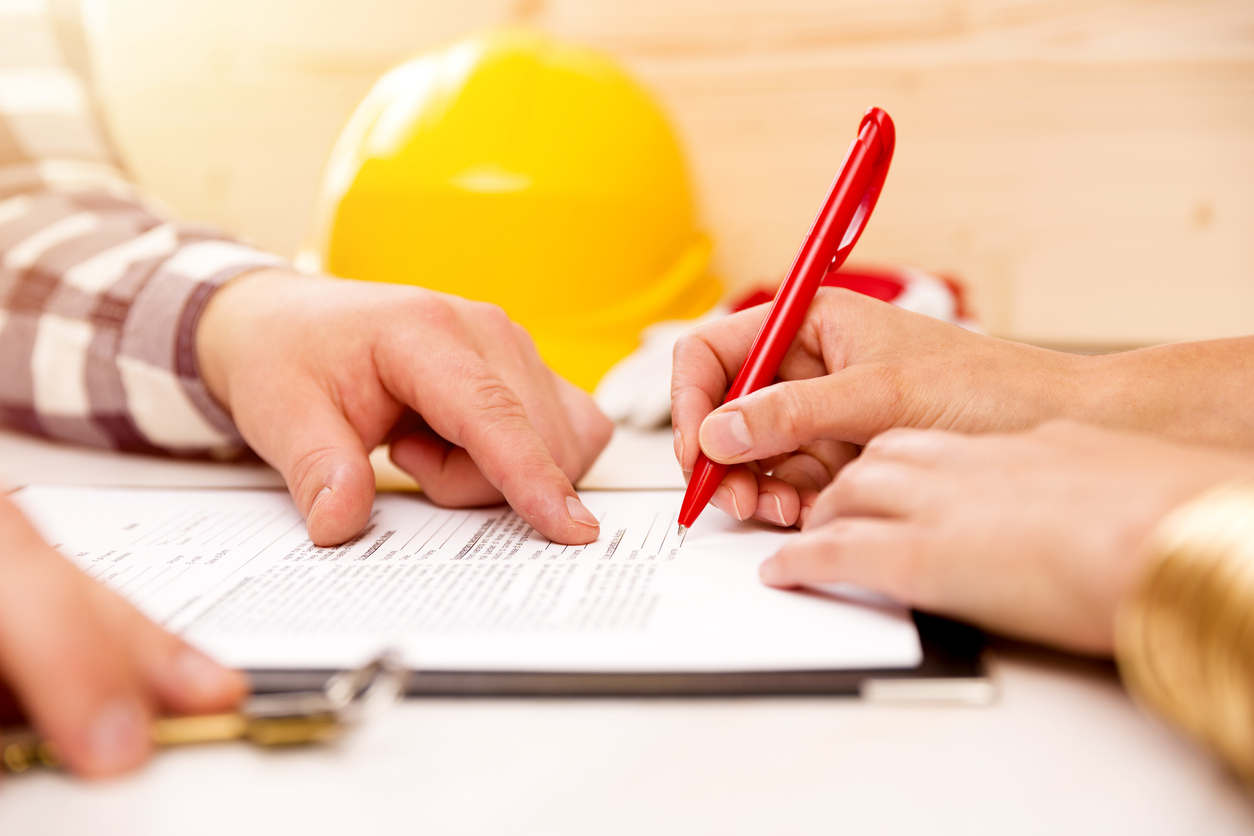 construction insurance evaluate paper and people reviewing signing